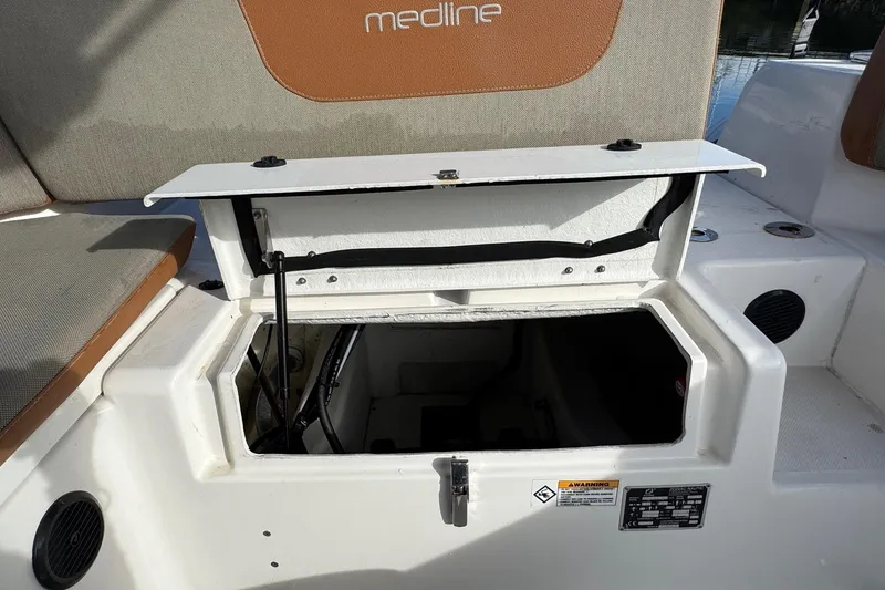 Slide: The Image of 2022 Zodiac Medline 6.8 boat storage compartment with open hatch and cushioned seating. - 14