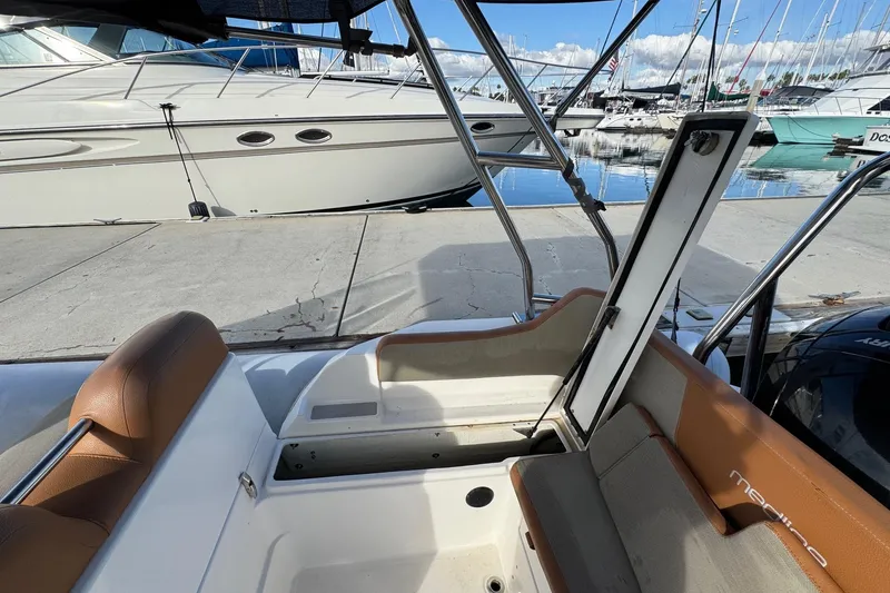 Slide: The Image of 2022 Zodiac Medline 6.8 boat interior with seating and open storage compartment. - 20