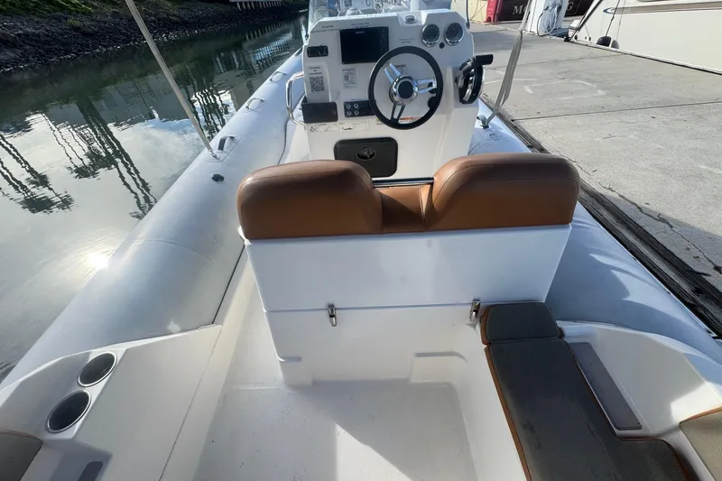 Slide: The Image of 2022 Zodiac Medline 6.8 boat interior with steering console and seating. - 22