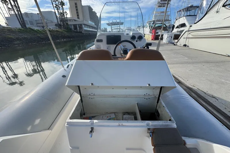 Slide: The Image of 2022 Zodiac Medline 6.8 boat interior with open storage compartment at marina. - 23
