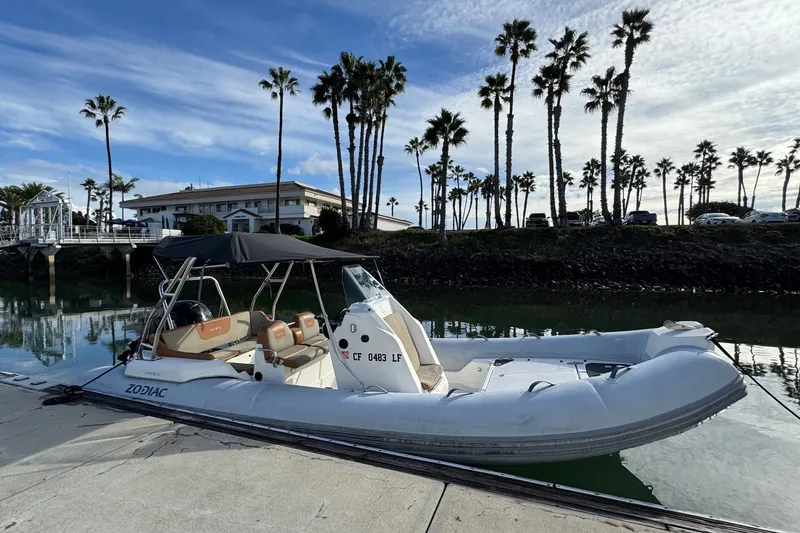 Slide: The Image of 2022 Zodiac Medline 6.8 boat docked by palm trees under a blue sky. - 3