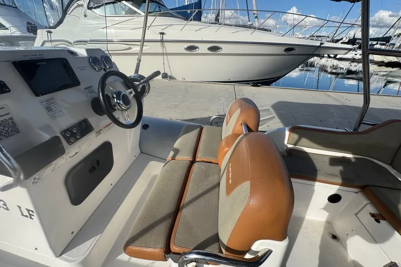 Slide: The Image of 2022 Zodiac Medline 6.8 boat interior with steering wheel and seating at marina. - 31