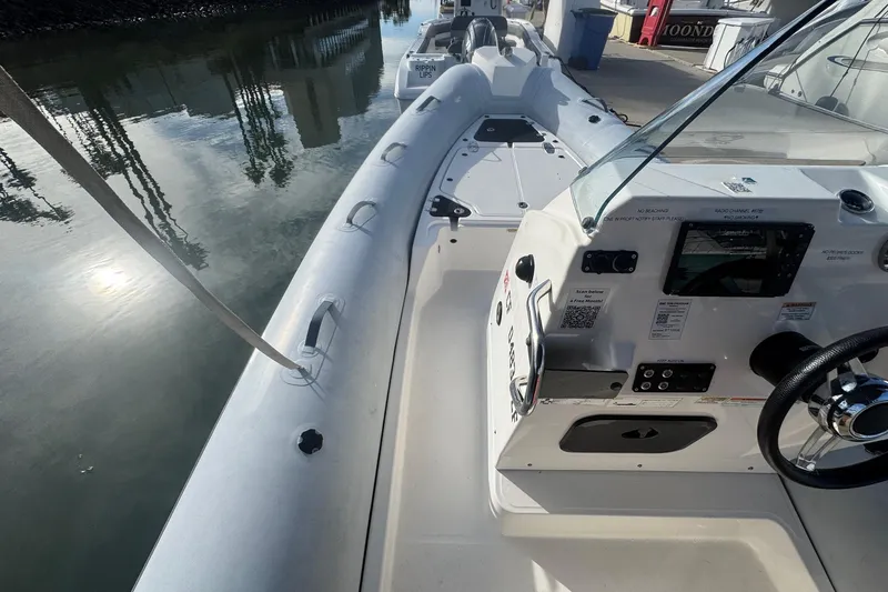 Slide: The Image of 2022 Zodiac Medline 6.8 boat docked, featuring sleek design and modern controls. - 32