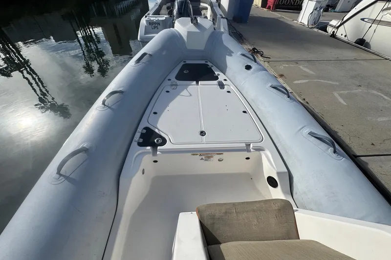 Slide: The Image of 2022 Zodiac Medline 6.8 boat docked, showcasing spacious deck and seating area. - 33