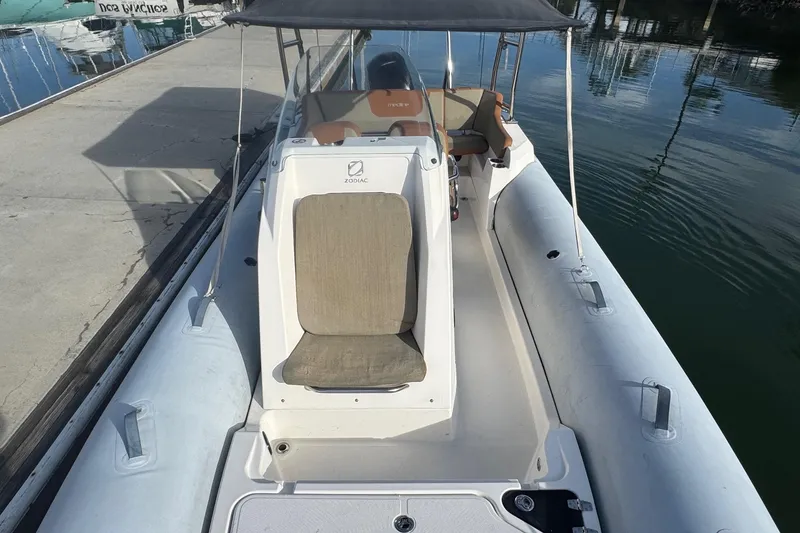Slide: The Image of 2022 Zodiac Medline 6.8 boat docked, featuring spacious seating and canopy. - 34