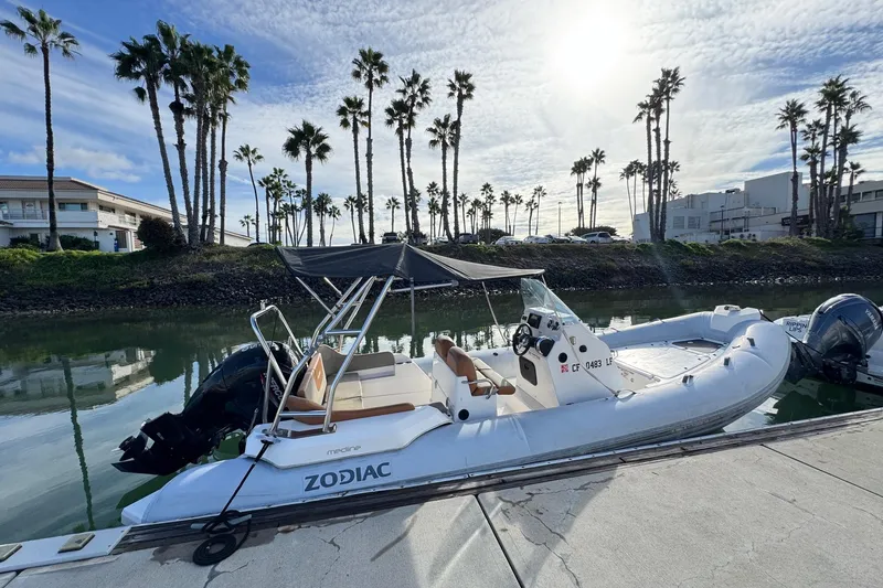Slide: The Image of 2022 Zodiac Medline 6.8 boat docked by palm trees under a sunny sky. - 4