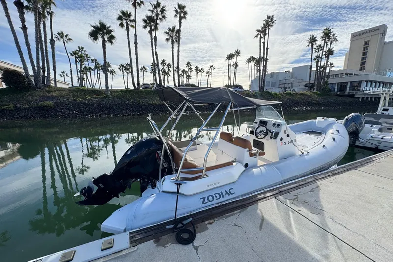 Slide: The Image of 2022 Zodiac Medline 6.8 boat docked by palm trees and hotel. - 5