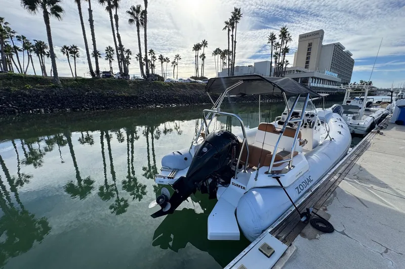 Slide: The Image of 2022 Zodiac Medline 6.8 boat docked by palm trees and hotel. - 6