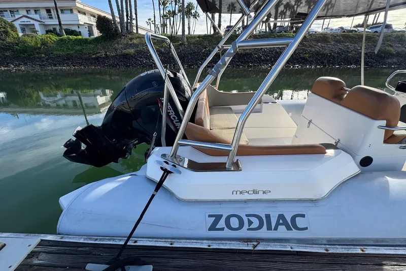 Slide: The Image of 2022 Zodiac Medline 6.8 boat docked, featuring a Mercury outboard motor. - 8