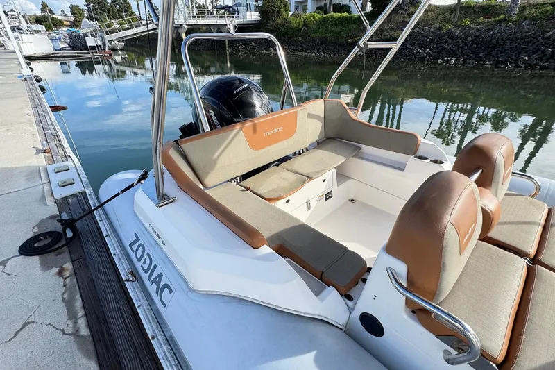 Slide: The Image of 2022 Zodiac Medline 6.8 boat docked, featuring spacious seating and sleek design. - 9