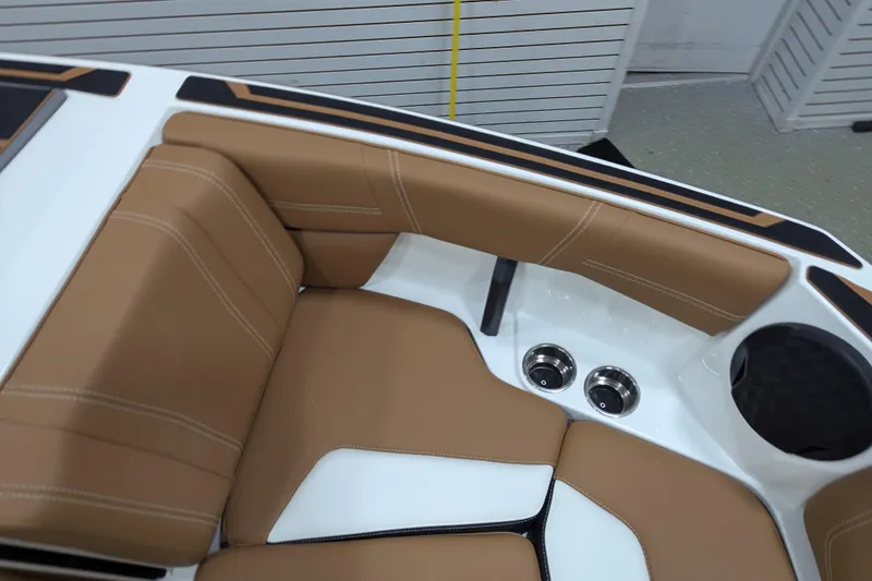 Slide: The Image of 2026 Malibu Wakesetter 21 LX interior with tan and white seating, cup holders, and speaker. - 14