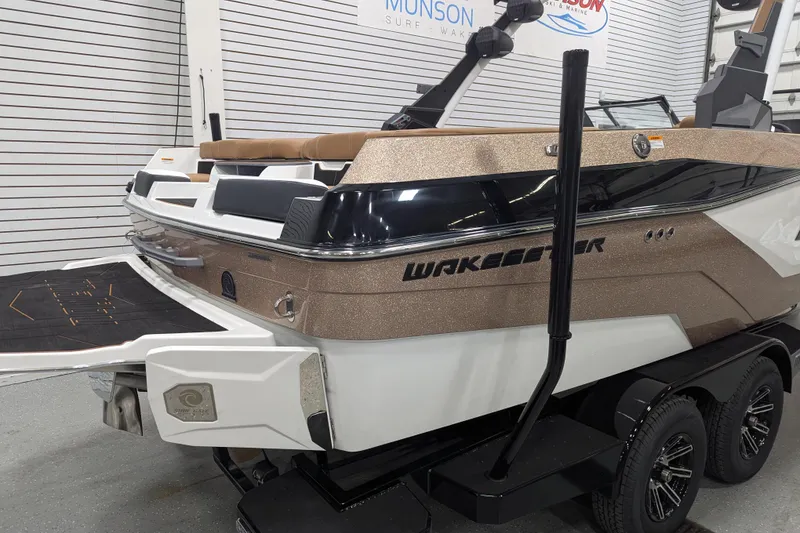 Slide: The Image of 2026 Malibu Wakesetter 21 LX boat displayed indoors on a trailer. - 2