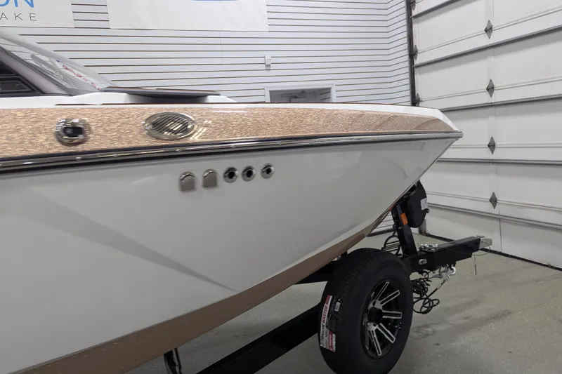 Slide: The Image of 2026 Malibu Wakesetter 21 LX boat in showroom, featuring sleek design and modern finishes. - 6