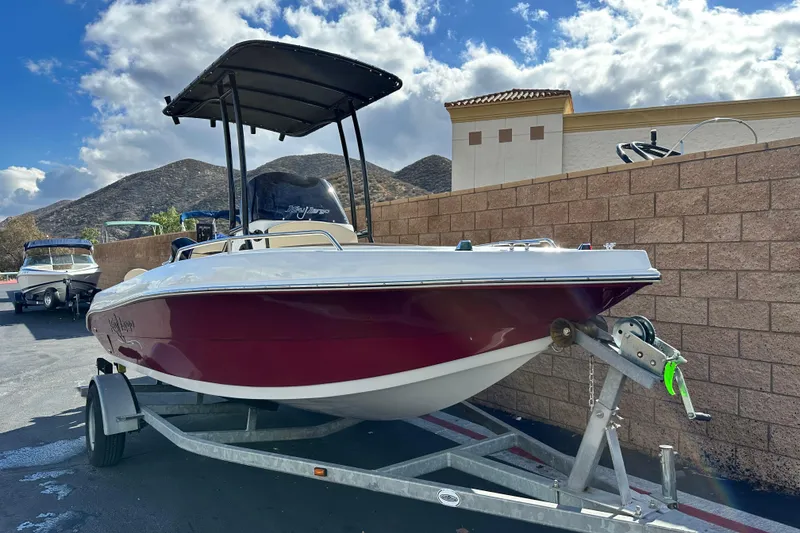 Slide: The Image of 2021 Key Largo 1801 boat on trailer, parked outdoors with scenic mountain backdrop. - 1