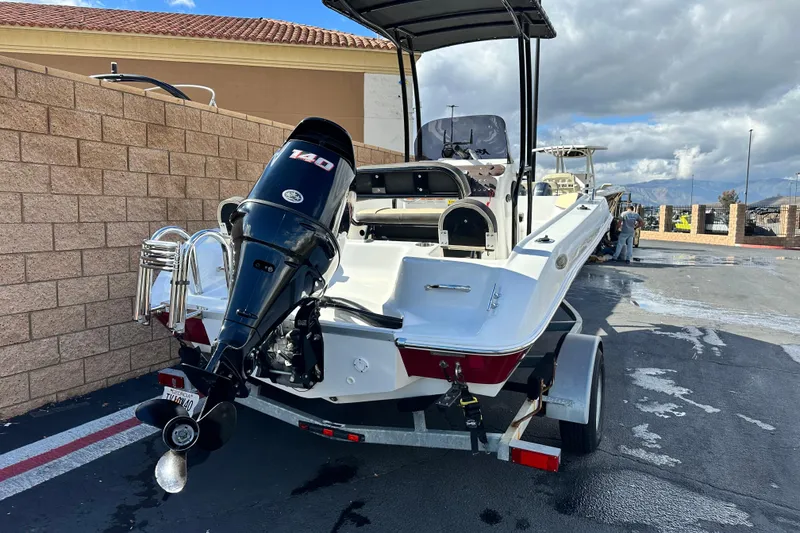 Slide: The Image of 2021 Key Largo 1801 boat on trailer, parked outdoors under a blue sky. - 3