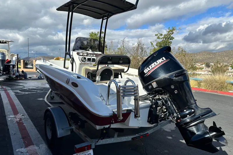 Slide: The Image of 2021 Key Largo 1801 boat with Suzuki outboard motor on trailer, parked outdoors. - 5