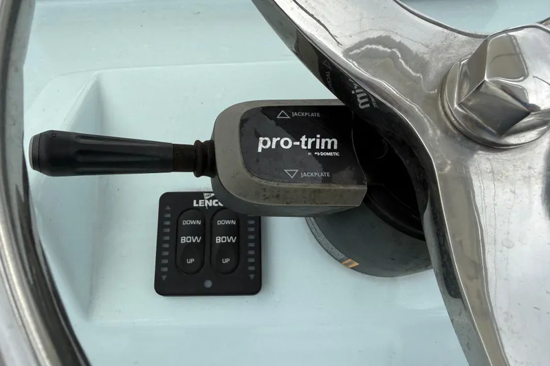 Slide: The Image of Close-up of 2023 Shallow Sport 25 X3 boat controls, featuring pro-trim and Lenco buttons. - 11