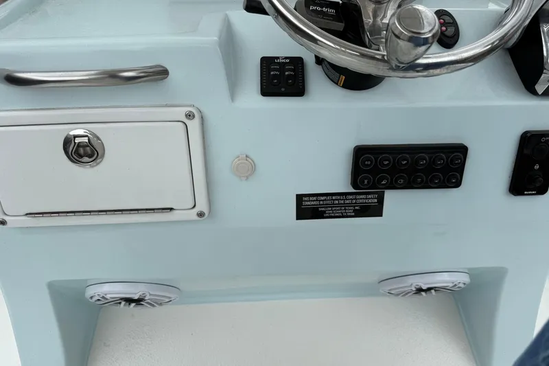 Slide: The Image of 2023 Shallow Sport 25 X3 boat dashboard with steering wheel and control panel. - 13
