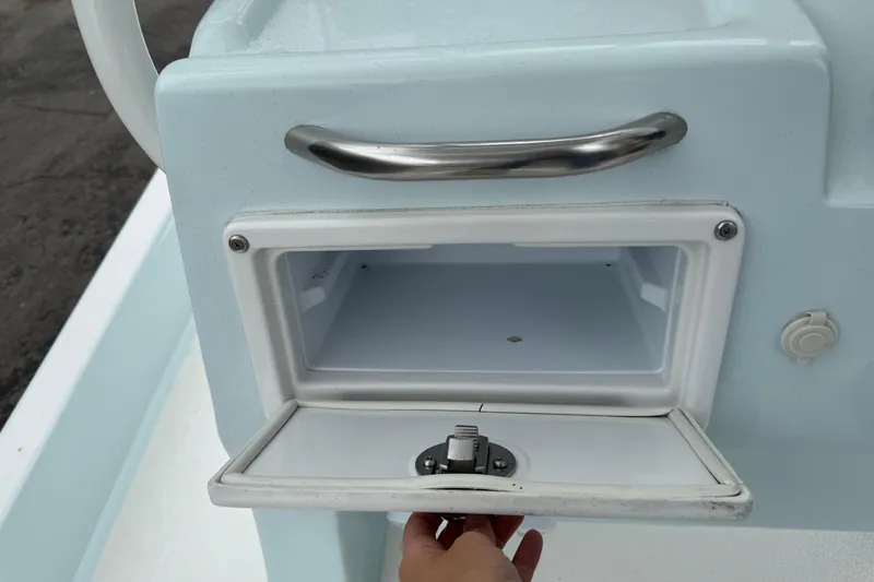 Slide: The Image of Open storage compartment on 2023 Shallow Sport 25 X3 boat with stainless steel handle. - 14