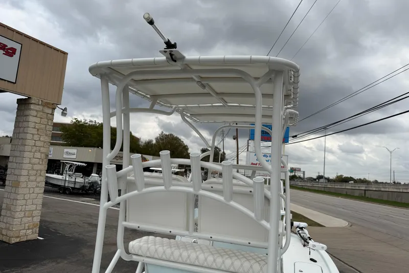 Slide: The Image of 2023 Shallow Sport 25 X3 boat with rod holders and seating, under cloudy sky. - 27