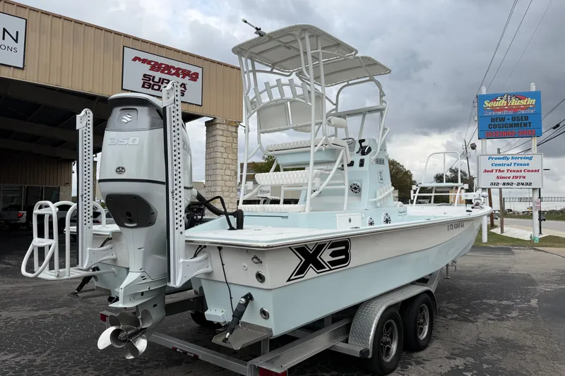 Slide: The Image of 2023 Shallow Sport 25 X3 boat on trailer, featuring Suzuki 350 engine. - 3