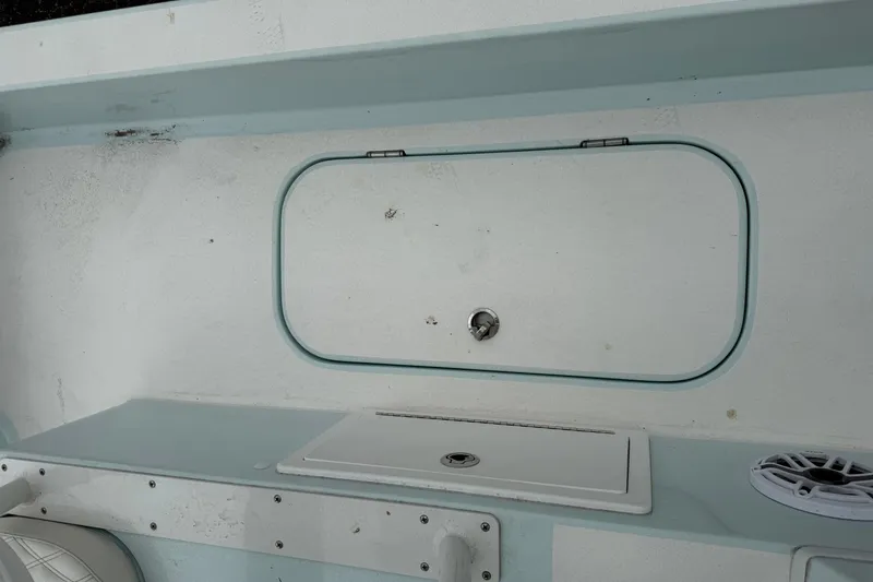 Slide: The Image of 2023 Shallow Sport 25 X3 boat interior with storage compartment and speaker. - 32