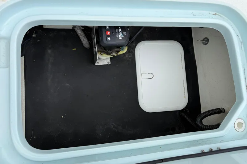 Slide: The Image of 2023 Shallow Sport 25 X3 boat compartment with battery and storage hatch. - 35