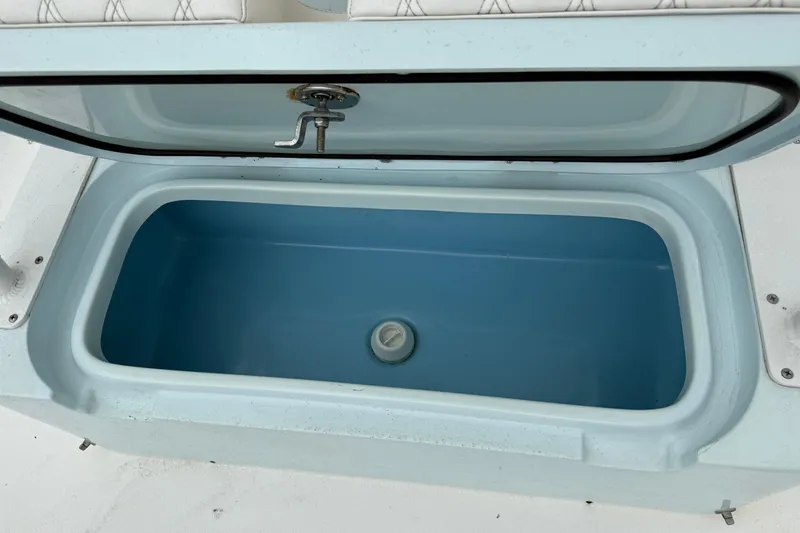 Slide: The Image of Open storage compartment on 2023 Shallow Sport 25 X3 boat, featuring a blue interior. - 40