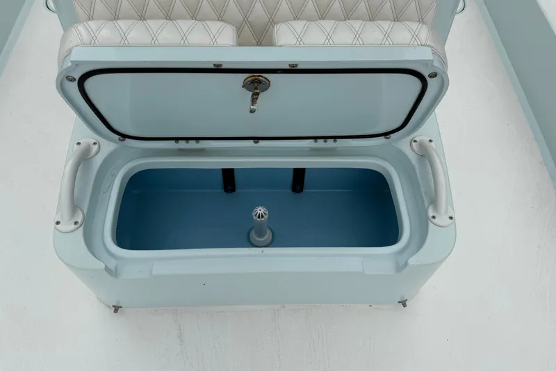 Slide: The Image of 2023 Shallow Sport 25 X3 boat storage compartment with open lid and cushioned seat. - 43
