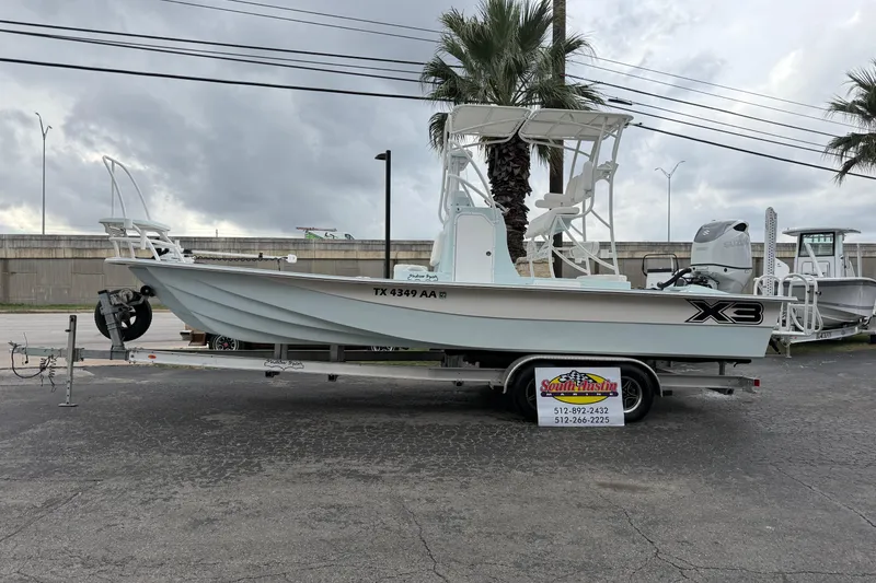 Slide: The Image of 2023 Shallow Sport 25 X3 boat on trailer, parked outdoors under cloudy sky. - 63