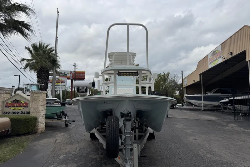 Slide: The Image of 2023 Shallow Sport 25 X3 boat on trailer at dealership, cloudy sky background. - 7