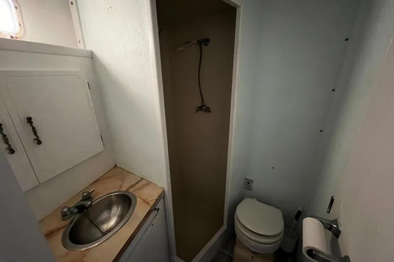 Slide: The Image of 1974 Tollycraft 37 Convertible bathroom with sink, shower, and toilet. - 37