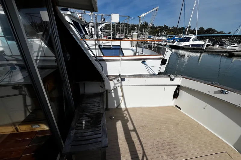Slide: The Image of 1974 Tollycraft 37 Convertible yacht docked at marina, showcasing spacious deck area. - 17