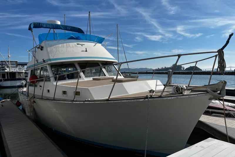The Image of 1974 Tollycraft 37 Convertible yacht docked at marina under clear blue sky. - 0