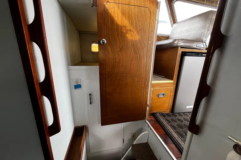 Slide: The Image of Interior view of a 1974 Tollycraft 37 Convertible boat, featuring wooden cabinetry and seating. - 33