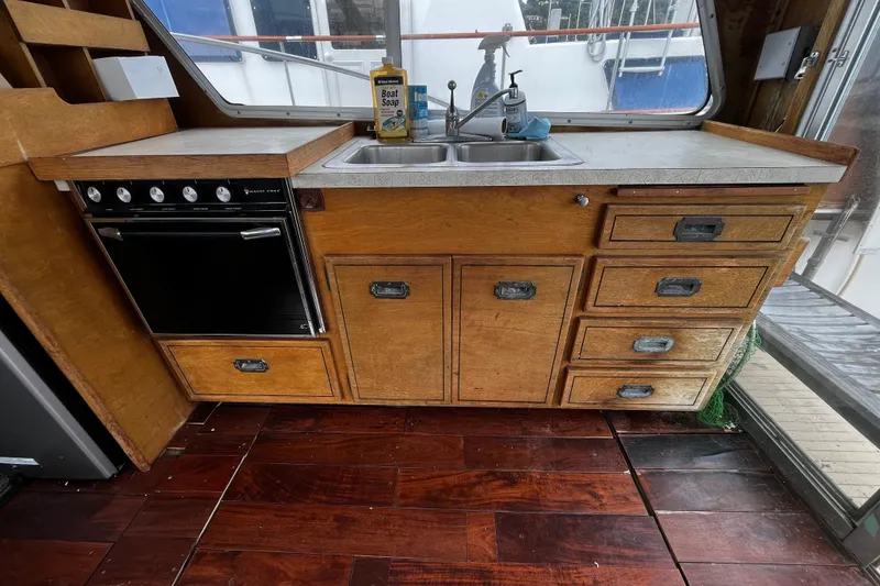 Slide: The Image of 1974 Tollycraft 37 Convertible kitchen with wooden cabinets, stove, and sink. - 22