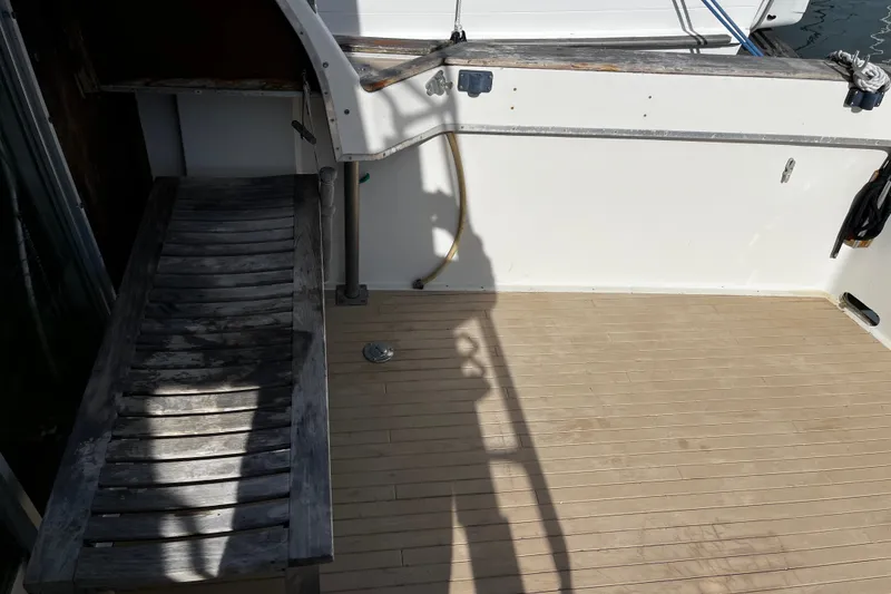 Slide: The Image of 1974 Tollycraft 37 Convertible boat deck with wooden bench and railing. - 15