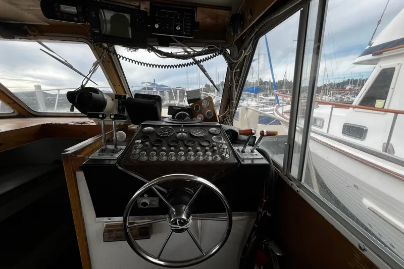 Slide: The Image of 1974 Tollycraft 37 Convertible boat helm with controls and marina view. - 25