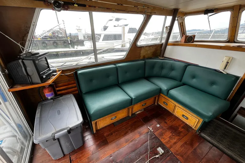 Slide: The Image of 1974 Tollycraft 37 Convertible interior with green seating, wooden flooring, and a small TV. - 18
