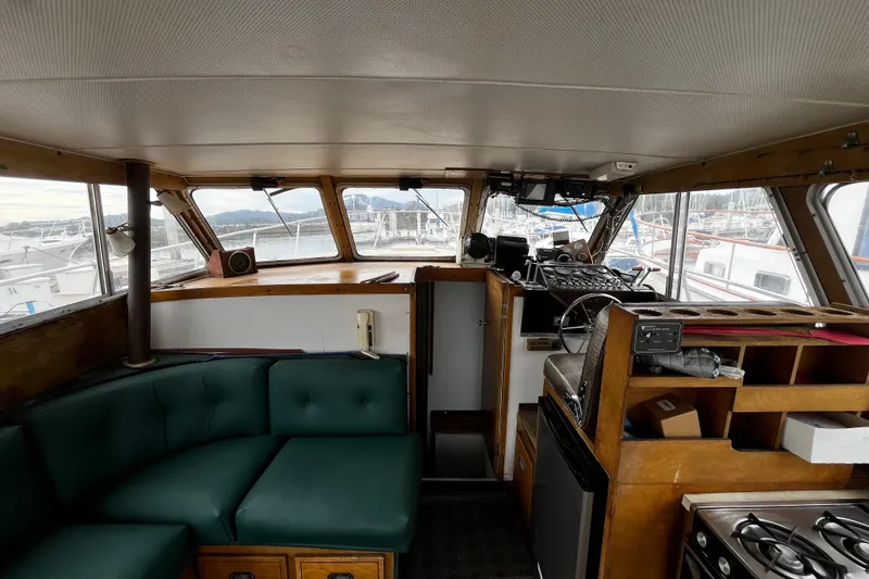 Slide: The Image of Interior of a 1974 Tollycraft 37 Convertible boat with green seating and wooden cabinetry. - 19