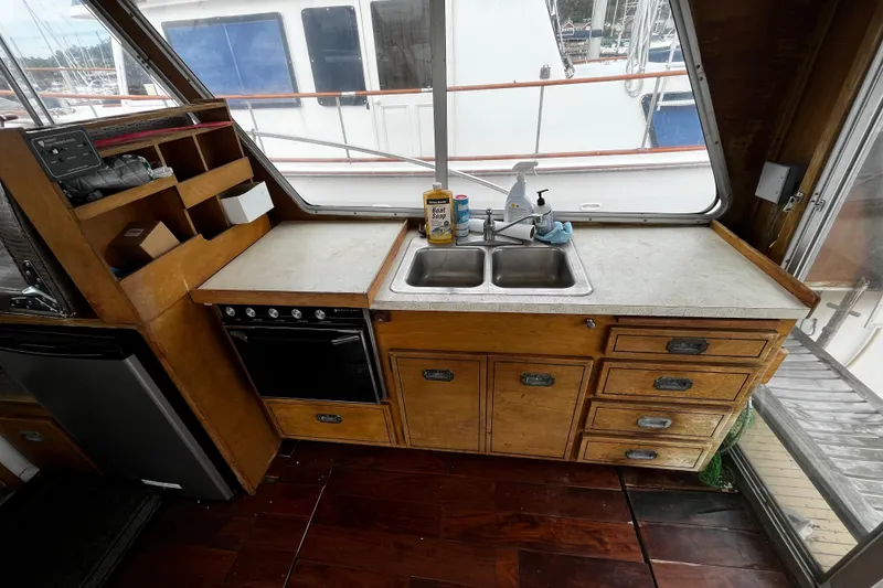 Slide: The Image of 1974 Tollycraft 37 Convertible boat kitchen with wooden cabinets and dual sink. - 21