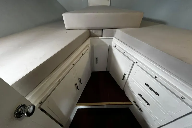 Slide: The Image of 1974 Tollycraft 37 Convertible cabin interior with white cabinetry and cushioned seating. - 40