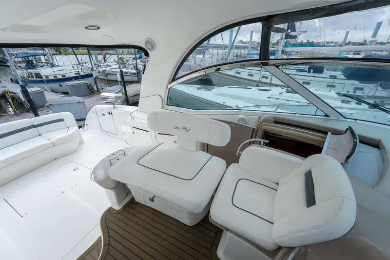 Slide: The Image of 2005 Sea Ray 500 Sundancer yacht interior with white seating and marina view. - 17