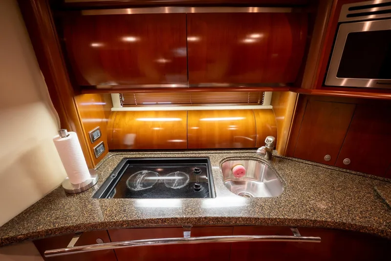 Slide: The Image of Luxurious kitchen interior of 2005 Sea Ray 500 Sundancer yacht with wood cabinetry and modern appliances. - 32