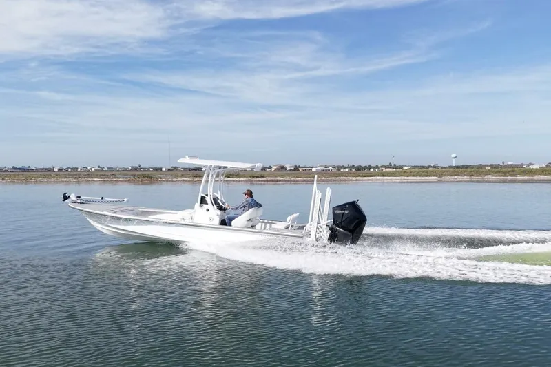 Slide: The Image of 2023 Haynie 25 Magnum boat cruising on calm water under a clear blue sky. - 10