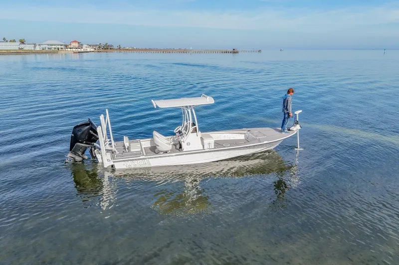 Slide: The Image of 2023 Haynie 25 Magnum boat on calm water with person standing at the bow. - 12