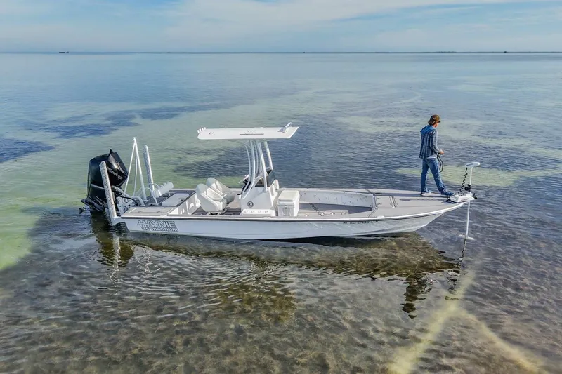 Slide: The Image of 2023 Haynie 25 Magnum boat on clear shallow water with a person standing on deck. - 13