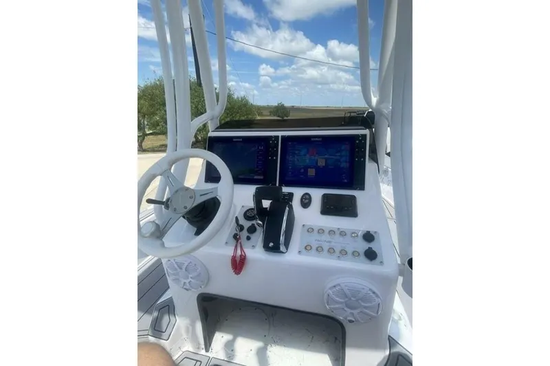 Slide: The Image of 2023 Haynie 25 Magnum boat console with steering wheel and dual navigation screens. - 15