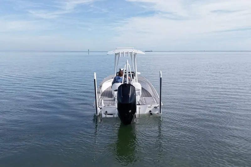 Slide: The Image of 2023 Haynie 25 Magnum boat on calm water, rear view with outboard motor. - 5