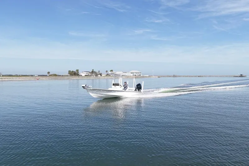 Slide: The Image of 2023 Haynie 25 Magnum boat cruising on calm waters under a clear blue sky. - 8